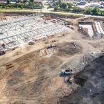 Luftaufnahme einer riesigen Baustelle mit vielen funktionierenden schweren Maschinen